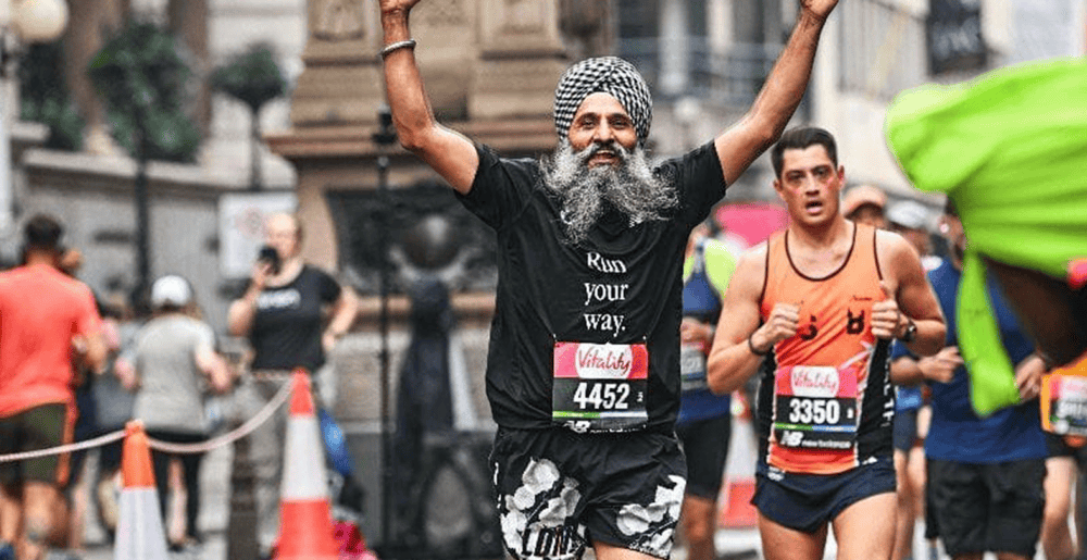 Sikhs In The City runner celebrating at a marathon finish line